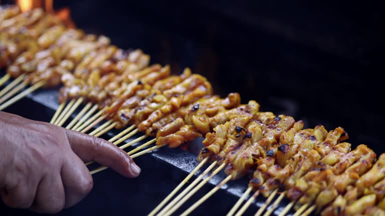 The popular Malaysian street food, Satay, is cooked on a flaming barbecue grill.