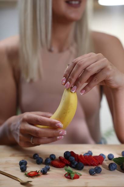 istock Woman holding a banana 1555457360