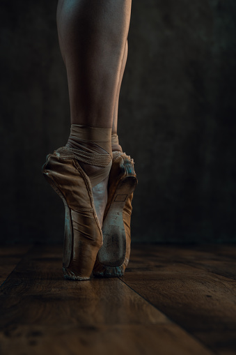 Close up of ballet shoes in dark room