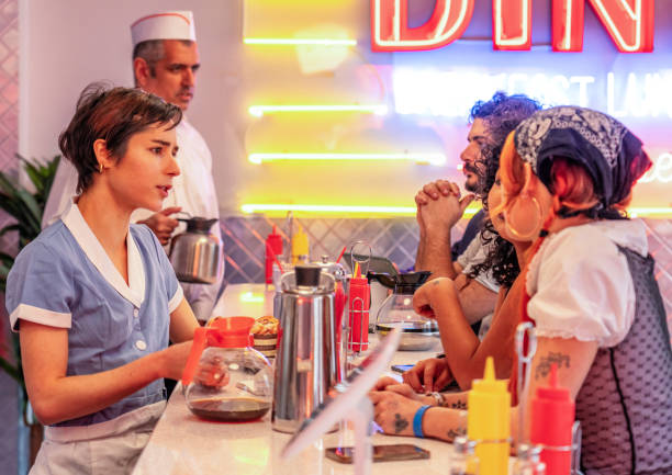 istock Waitress and waiter looking after customers in a diner 1555510771