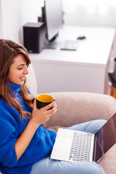 istock Woman drinking coffee while working from home 1555533324