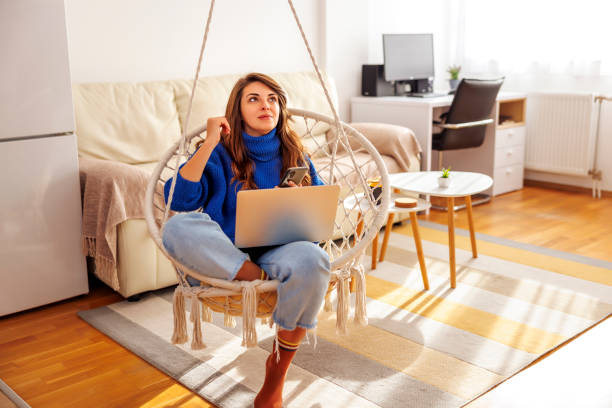 istock Woman using smart phone and laptop computer 1555538127