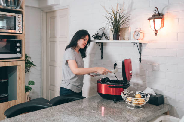 istock asian woman preparing rice in rice cooker 1555540799