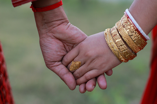 Close up image of newly married hindu couple holding hands of each other with love and trust, valentine’s day concept