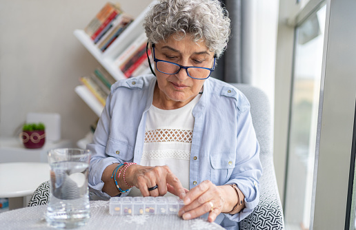 Senior Woman Scheduling Daily Dosage Of Medicines