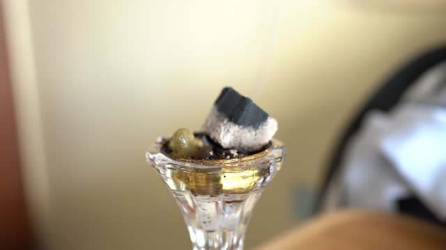 Small metal decorative Arabian Bakhoor incense burner emitting white smoke - aloeswood, essential oil and burning incense chips