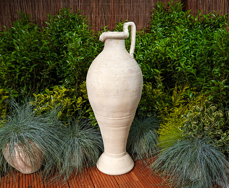 Ceramic Terracotta Amphora Clay Pot on veranda at green plants background
