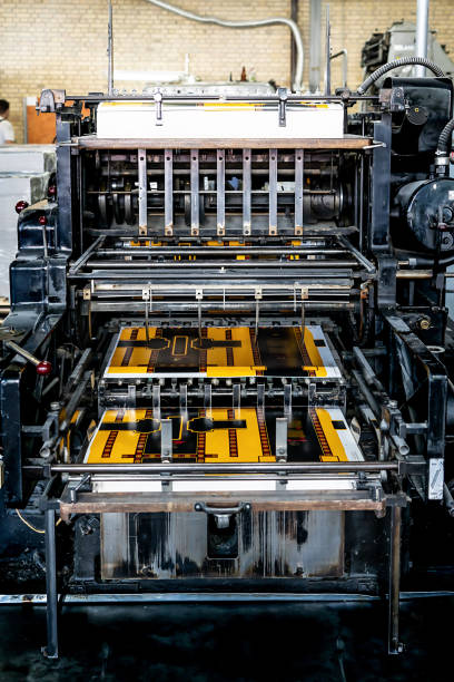 istock Offset printing machine feeder transfer metallic paper through the feeding table to the printing unit 1555557764