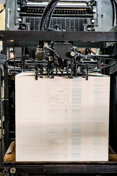 istock Offset printing machine feeder transfer metallic paper through the feeding table to the printing unit 1555559374