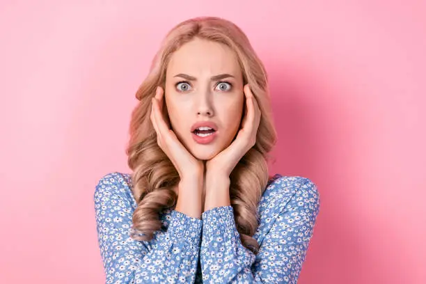 Photo of Closeup portrait of young blonde wavy hair woman confused fingers touching temples stressed staring isolated on pink color background