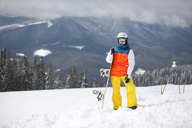istock female snowboarder against sun and sky 155557312