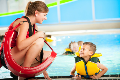 Swim instructor talking with student by the pool