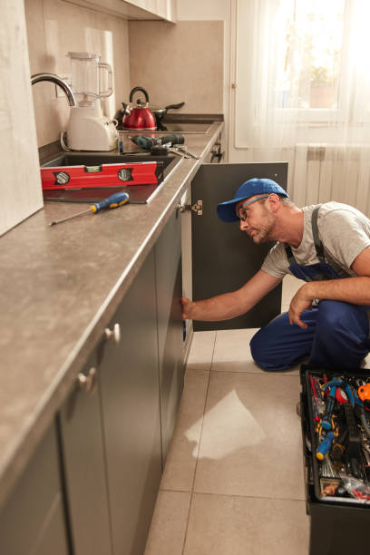 istock Plumber fixing and repairing water pipes under the kitchen sink. 1555576713