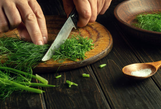 istock The cook hands cut fresh fennel with a knife on a kitchen cutting board before preparing national or vegetarian dishes. Peasant cuisine 1555577276
