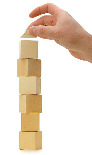 istock A hand stacking wooden blocks on top of each other  155557798