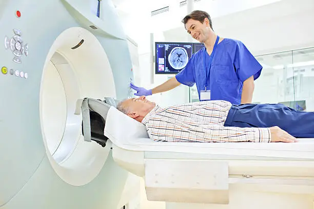 Patient and medical technician at the computer tomography getting a scan