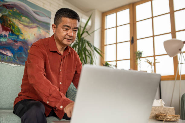 istock Mature man using a laptop at home 1555582245