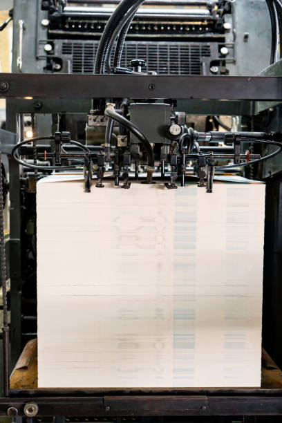 istock Offset printing machine feeder transfer metallic paper through the feeding table to the printing unit 1555606604