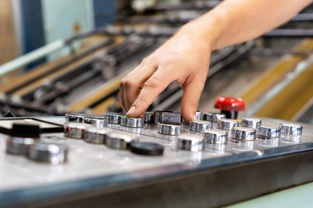 istock close up engineer hand finger press button controling cnc machine, Workers operating factory machinery in warehouse 1555607677