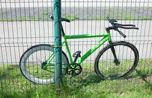 Sports racing bike attached to the fence with a lock with a cable. Protection of the bike from theft, theft.