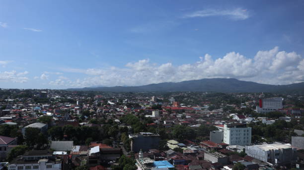 istock city and mountain view with blue and cloudy sky in Manado. 1555651540