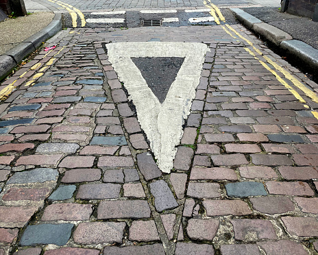 Give way sign on a cobbled street