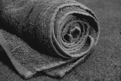 The object is a roll of towels on a rough carpet.