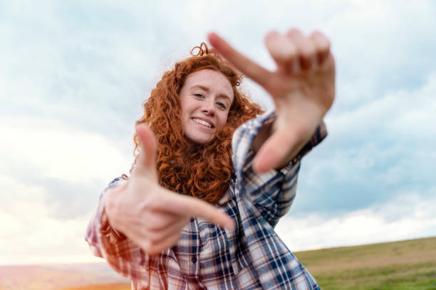 glückliche reisende in einer weißen jacke und einem rucksack, die die berge im peak district bereist und fotos per telefon macht.  lokales tourismus-lifestyle-konzept. - toll free audio stock-fotos und bilder