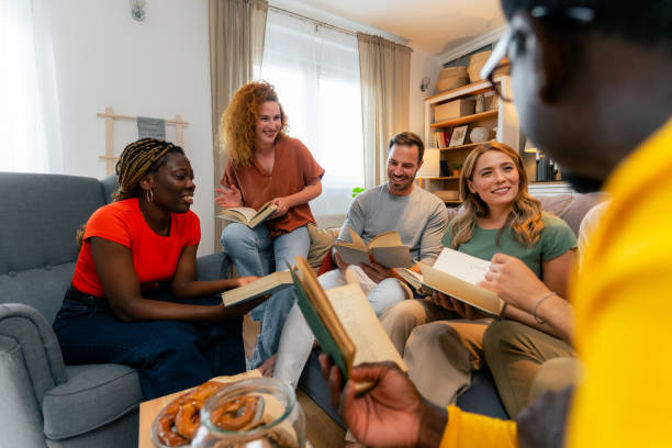 istock Happy diverse group of friends discussing a book 1555677763