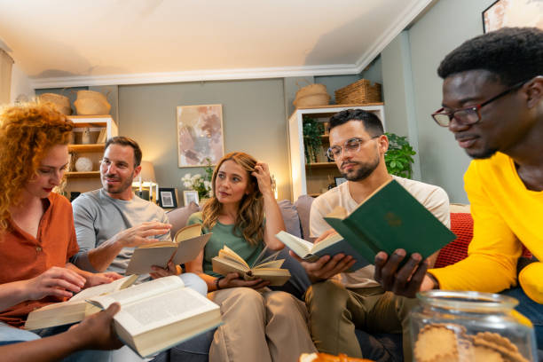 istock Diverse aged group of people reading books together 1555677768