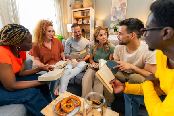 istock Diverse group of friends discussing a book at home. 1555678538