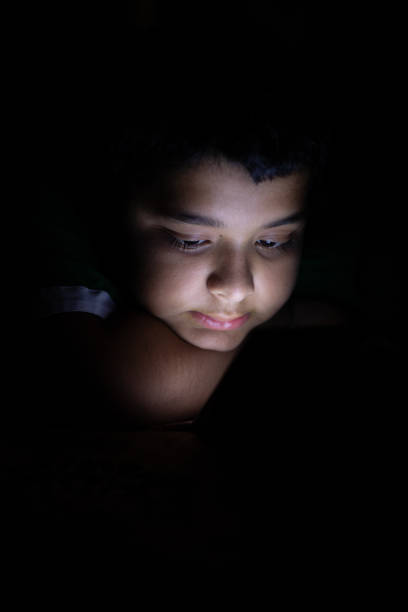 istock Close up of young kid using smart phone at night 1555694724