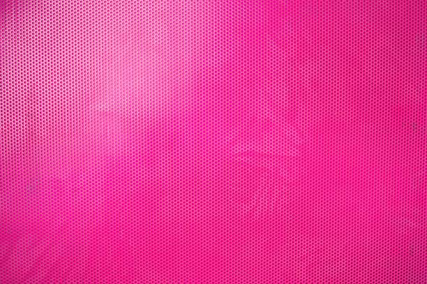 istock Closeup of a vibrant pink perforated background 1555695848