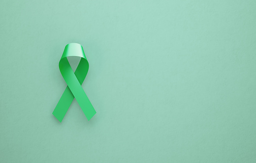 Mental health awareness ribbon on green background. Horizontal composition with copy space.