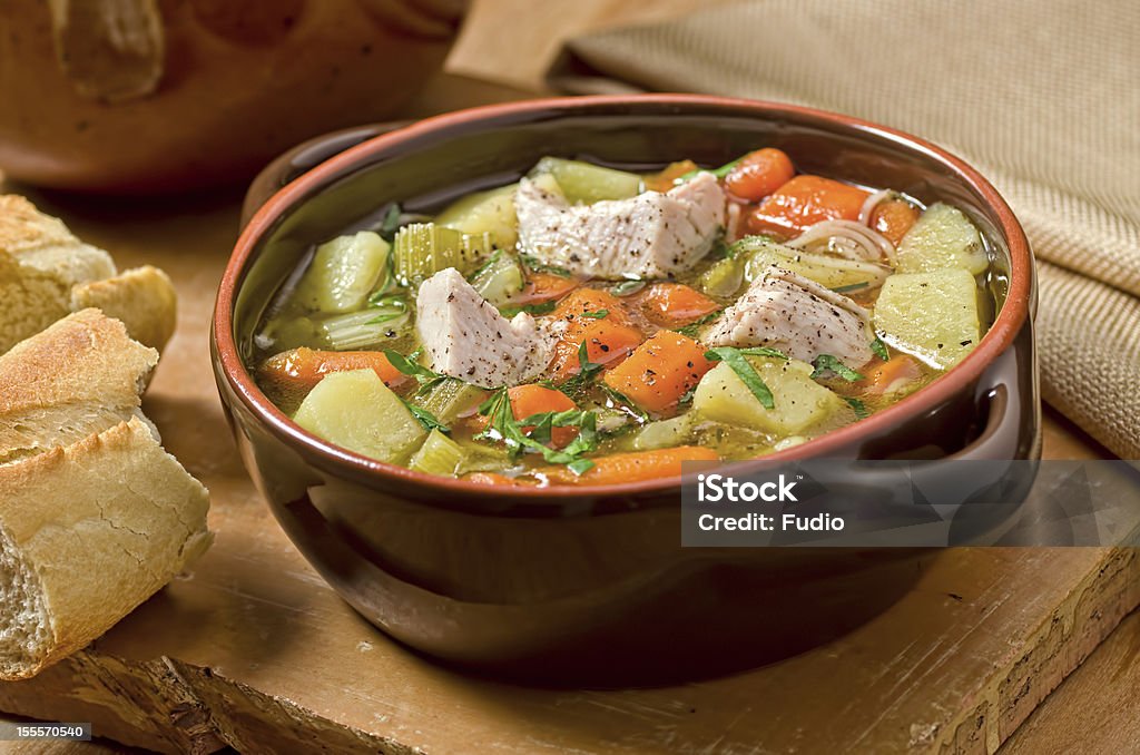 Turkey Soup A bowl of hearty, rustic turkey soup with french bread. Soup Stock Photo