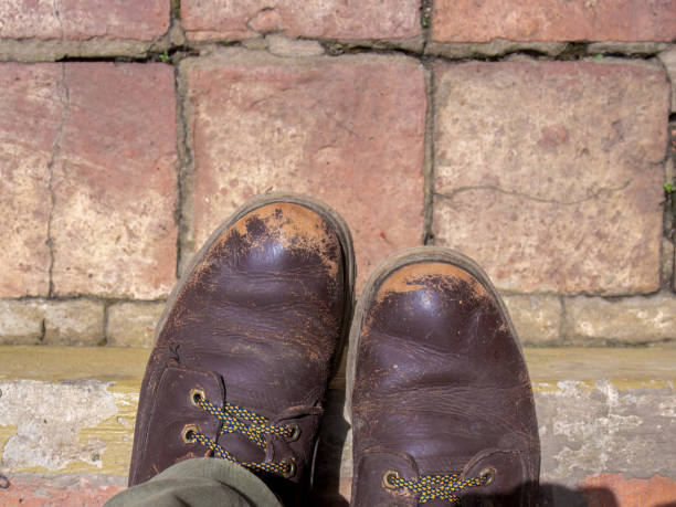 istock A pair of very worn leather boots on a clay tile floor 1555708231