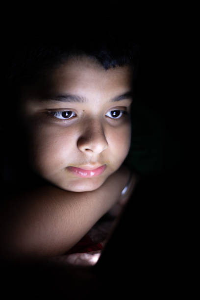 istock Close up of young kid using smart phone at night 1555721006