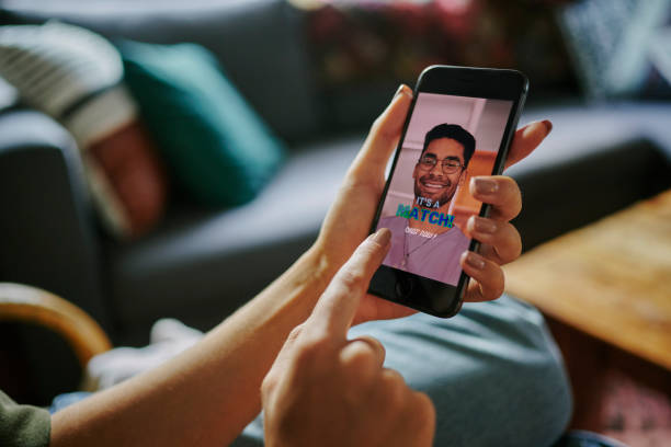 istock Woman lying on her sofa and opening a chat on a dating app profile 1555722587