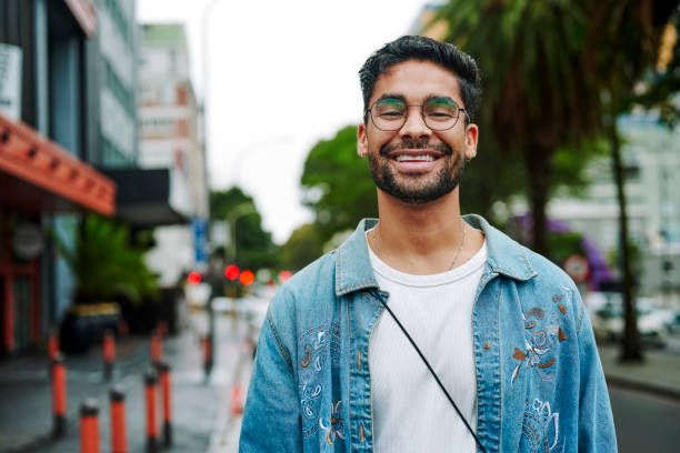 istock Laughing young man standing outside on a city sidewalk 1555723120