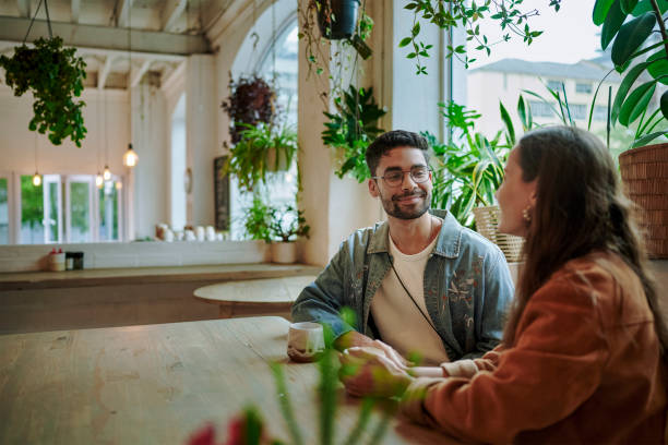 istock Smiling young man and woman having coffee and talking during a date 1555724703