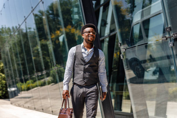 istock Happy businessman goes out from office building 1555727405