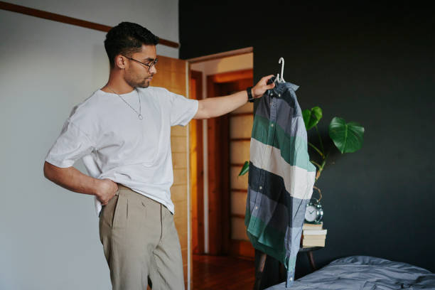Young man trying to choose an outfit before a date