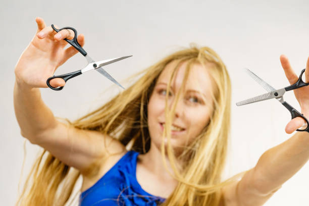 istock Girl with scissors for haircutting 1555734524