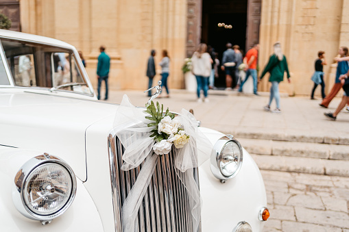 White wedding car parked in front of the cathedral in Mdina in Malta.