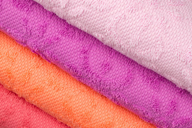 Rolls of crepe paper lying next to each other in the colors purple, red, orange, lilac