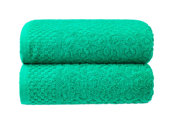 istock multicolored terry towels, rolled up and stacked on the table 1555778978