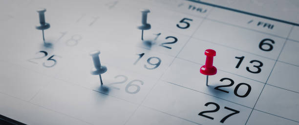 gestickte rote stifte auf einem kalender event planer kalender, uhr zum einstellen des zeitplans organisieren zeitplan, planung für geschäftstreffen oder reiseplanungskonzept. - caste system stock-fotos und bilder