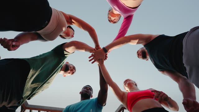 People bring hands together in unity gesture after workout