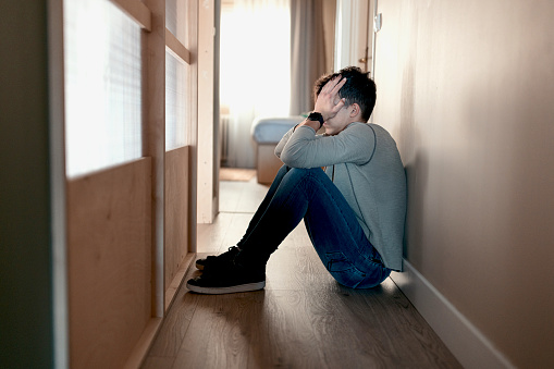 Sad and anxious teenager sitting at home