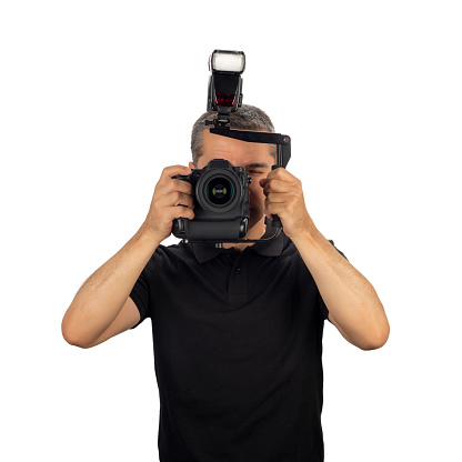 Professional photographer on job using big camera and speedlight isolated on white background